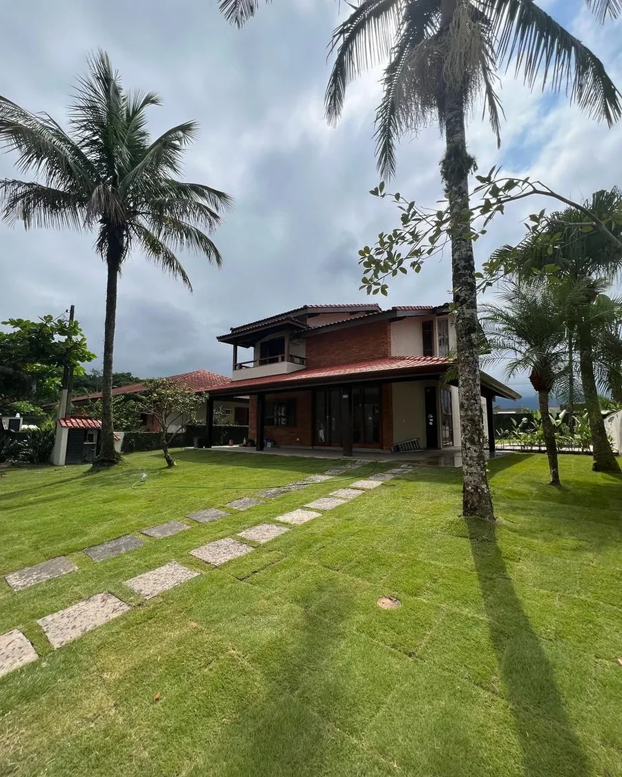 Fachada de casa entre palmeiras revestida com Brick Terra Cerrado